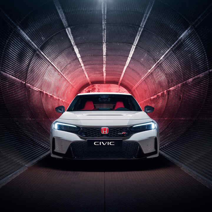 Widok z przodu na Hondę Civic Type R zaparkowaną w tunelu. 