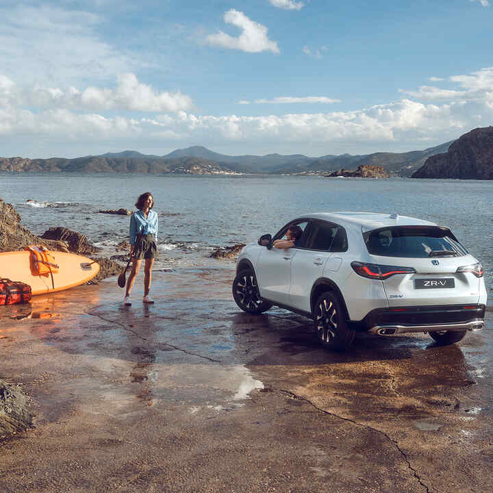 Biała Honda ZR-V na wybrzeżu z kobietą i kajakiem