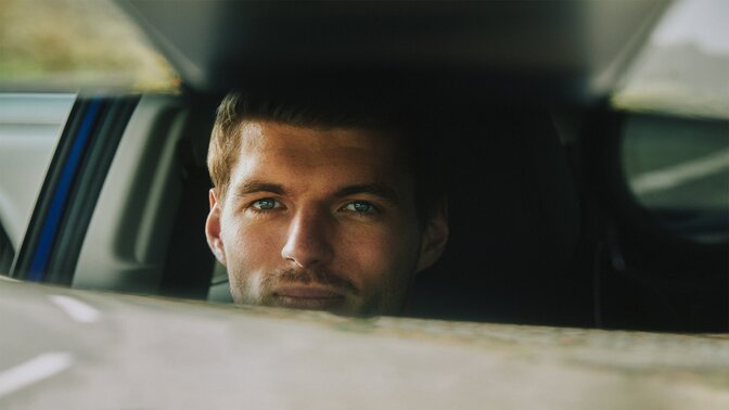 Max Verstappen patrzący w lusterko wsteczne hybrydowego SUVa ZR-V.