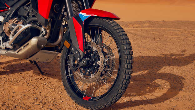 Zbliżenie kół motocykla CRF1100L Africa Twin na pustyni.