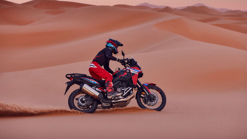 Model jadący po pustyni na motocyklu CRF1100L Africa Twin.