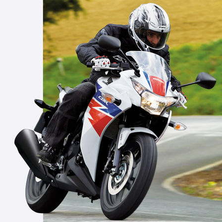 Honda CBR500R – niebiesko-czerwony motocykl z kierowcą z przedniej perspektywy.