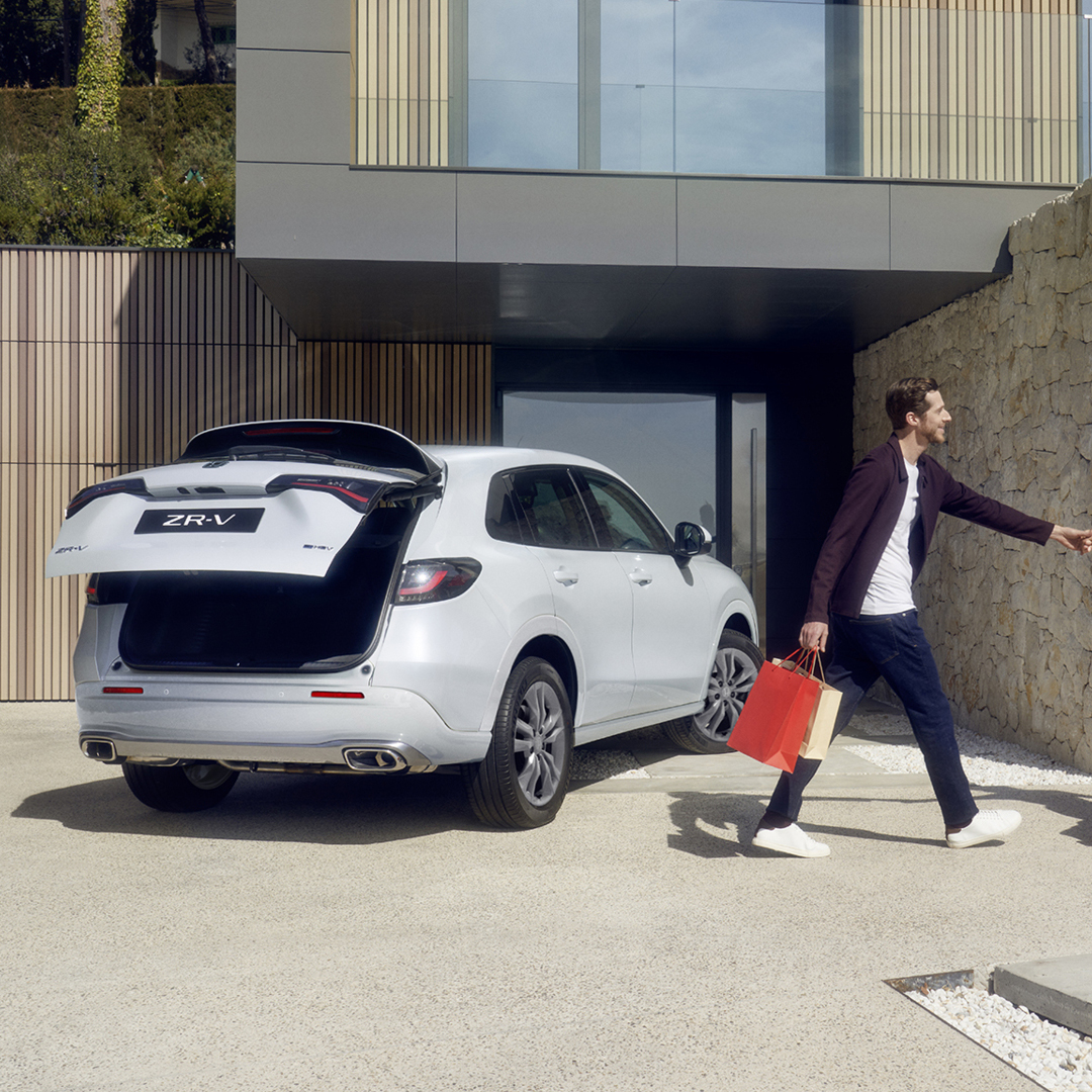 Biała Honda ZR-V na podjeździe z pokrywą bagażnika sterowaną elektrycznie