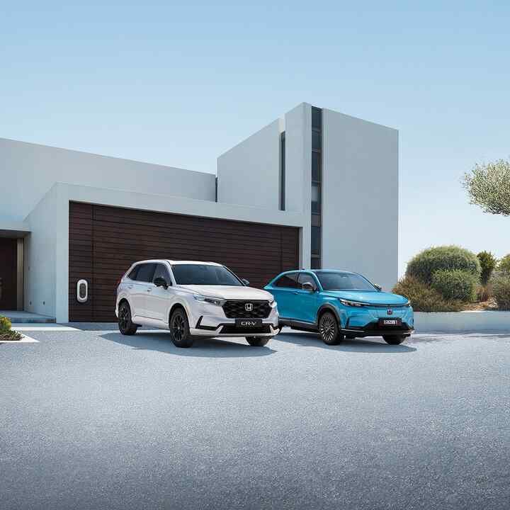 Gama hybrydowych samochodów Hondy na tle budynku.