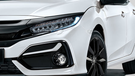 Zbliżenie na reflektory LED w białej Hondzie Civic.