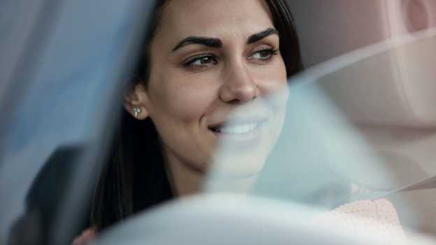 Zbliżenie na kobietę wyglądającą przez otwarte okno samochodu