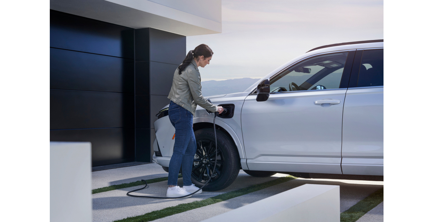Kobieta podłączająca swój samochód elektryczny Honda do ładowania