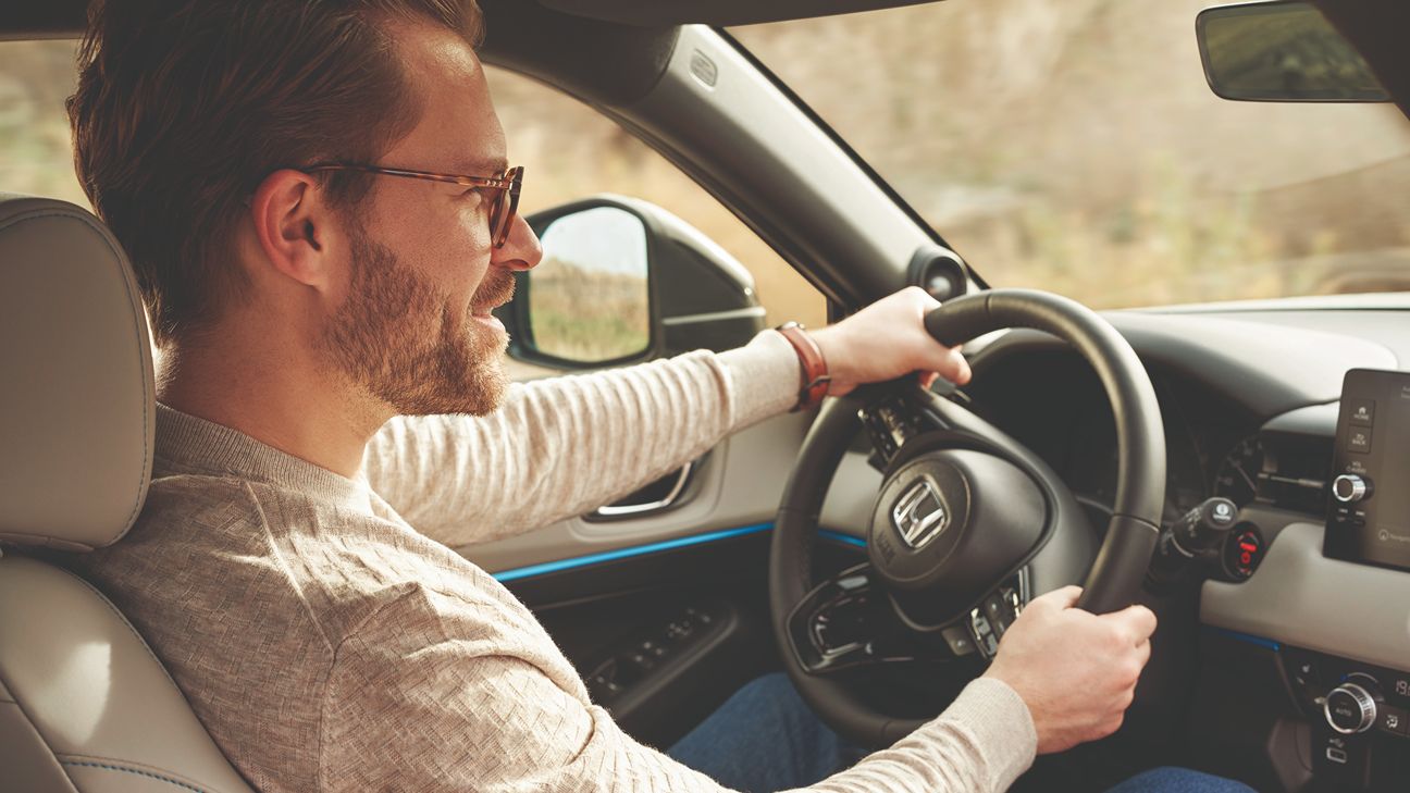 Mężczyzna w okularach prowadzi samochód marki Honda