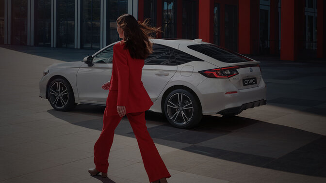 Kobieta podchodząca do hybrydy Civic
