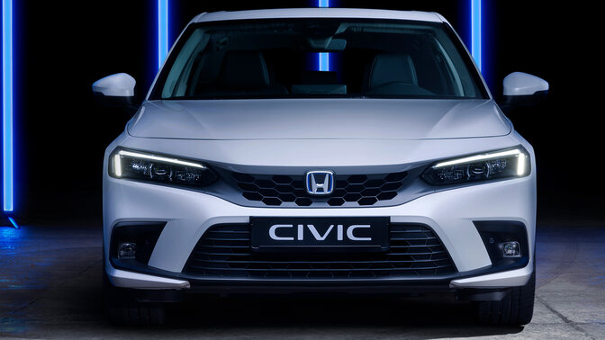 Zbliżenie na logo Hondy Civic e:HEV z tyłu samochodu.