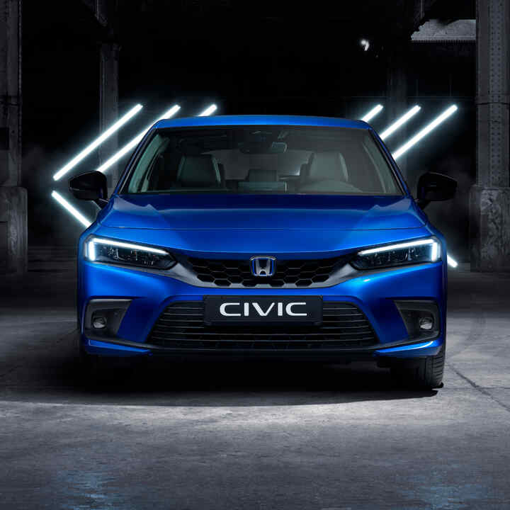 Honda Civic e:HEV hatchback zaparkowana w magazynie - widok z przedniej perspektywy.