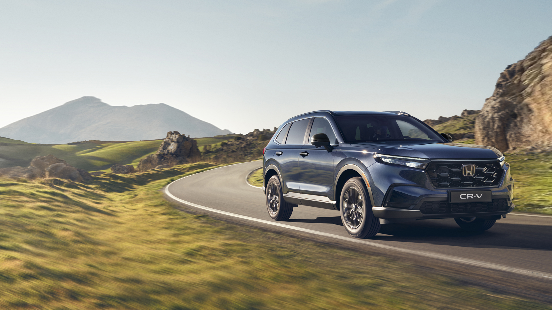 SUV CR-V z napędem Plug in Hybrid jadący drogą w górzystym terenie.