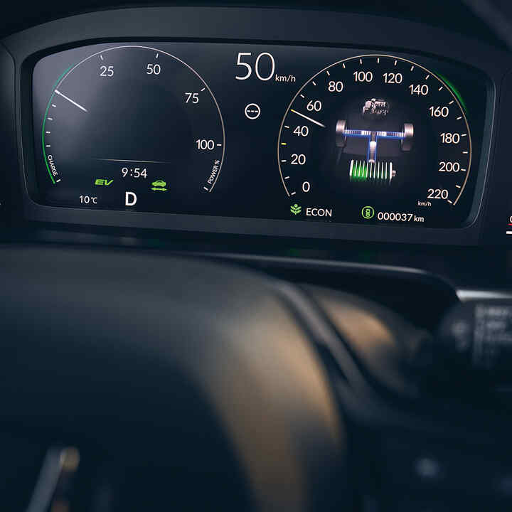 Zbliżenie na cyfrowy ekran kierowcy w hybrydowej Hondzie CR-V.