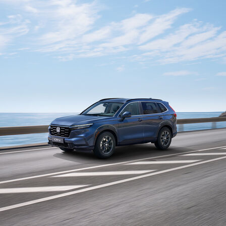 Side view of Honda CRV Hybrid SUV car driving in sea location.
