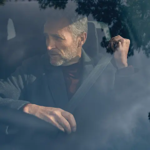 Zbliżenie na koło i bok hybrydowego SUVa CR-V zaparkowanego z modelem.