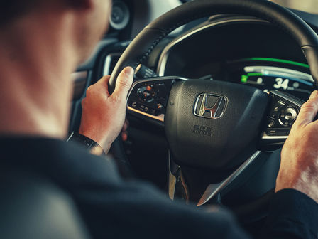 Zbliżenie przedstawiające wnętrze samochodu Honda CR-V Hybrid z kierownicą.