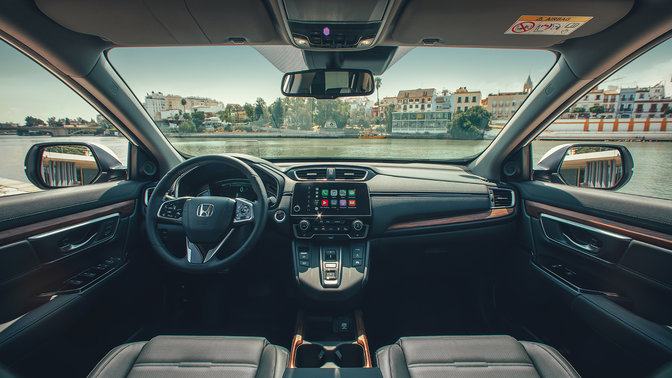 Zbliżenie przedstawiające deskę rozdzielczą Hondy CR-V Hybrid znajdującej się na ulicy.