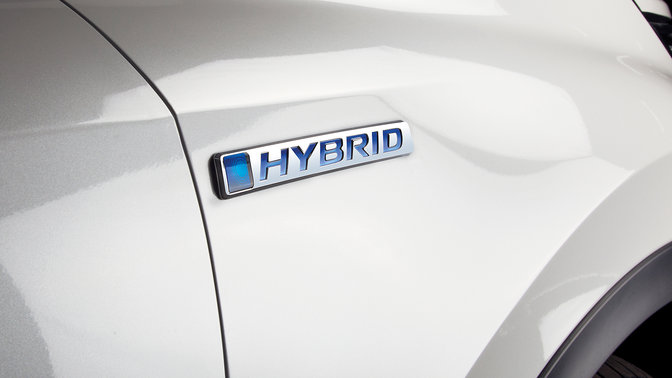 Zbliżenie na logo Hondy CR-V Hybrid z boku.