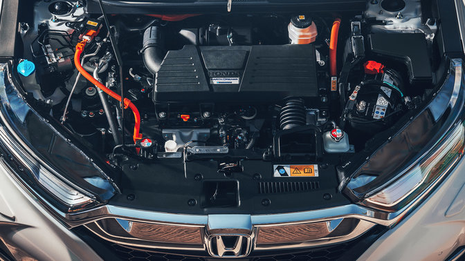 Zbliżenie od przodu na Hondę CR-V Hybrid z silnikiem benzynowym pracującym w cyklu Atkinsona.