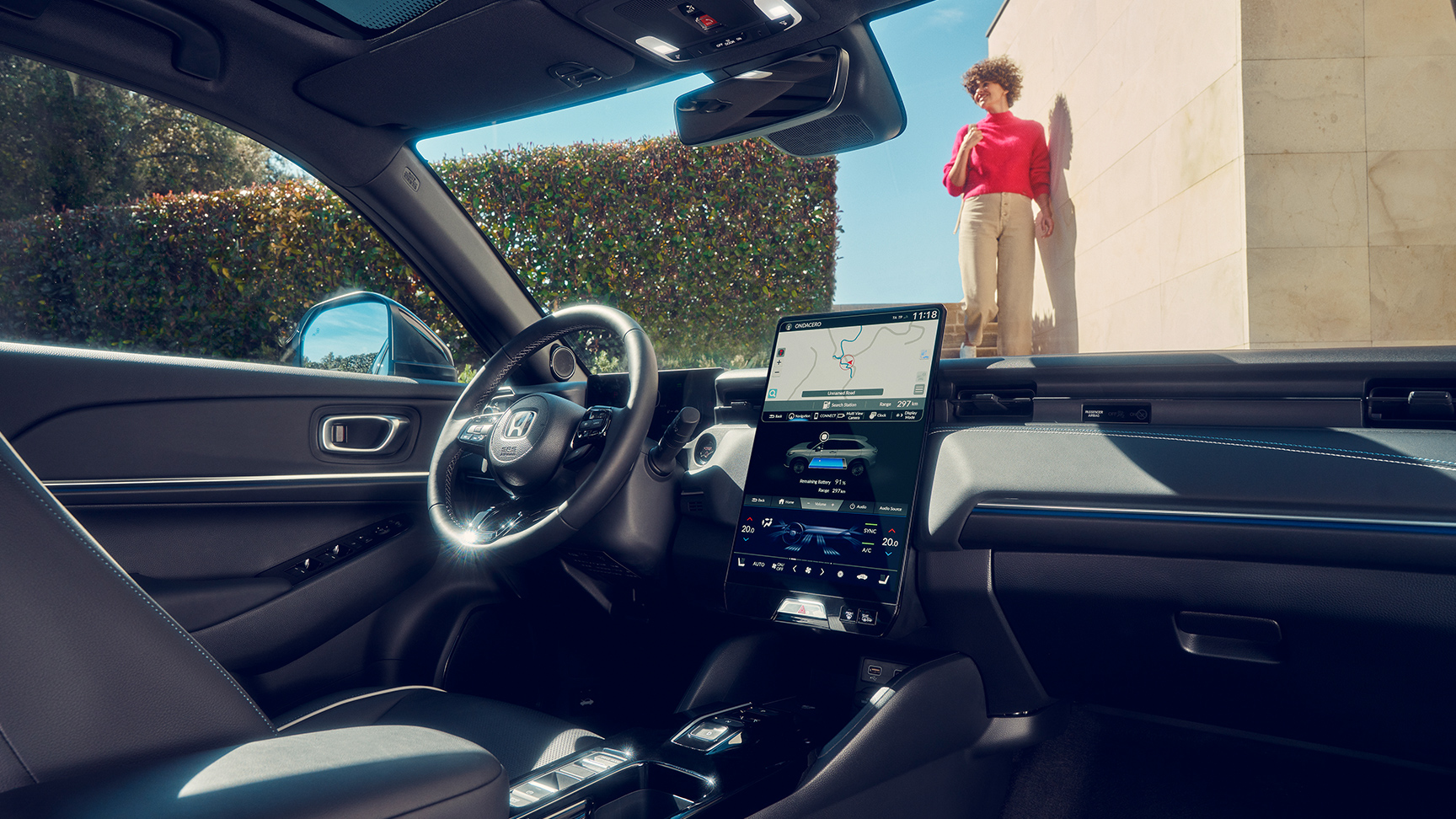 Widok na całą deskę rozdzielczą w kabinie z kobietą widoczną przez przednią szybę. 