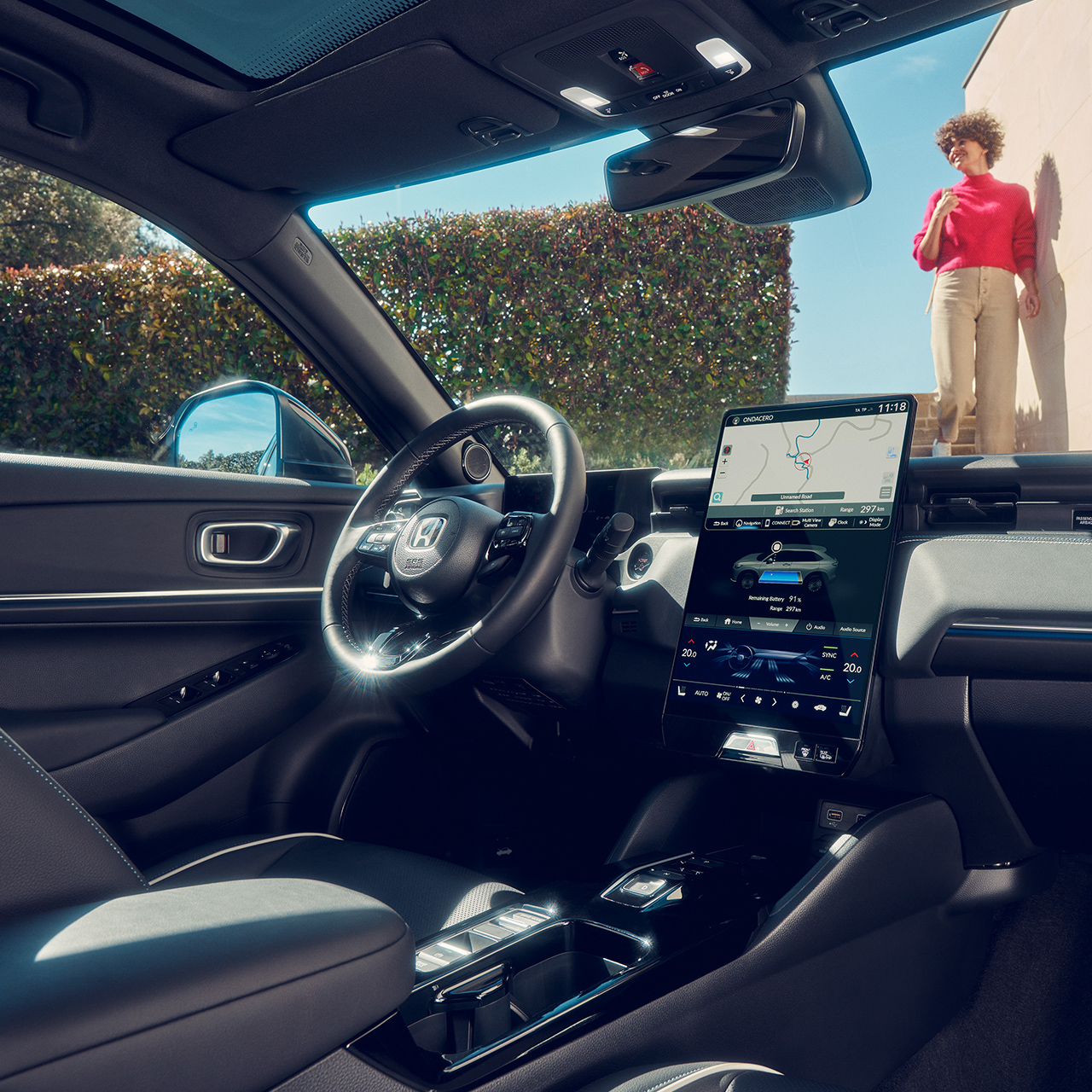 Widok na całą deskę rozdzielczą w kabinie z kobietą widoczną przez przednią szybę. 