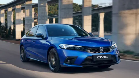 Hybrydowa Honda Civic w kolorze niebieskim jadąca w górskiej scenerii.