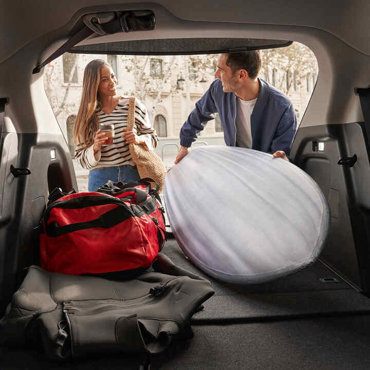 Para wkładająca walizki do bagażnik Hondy HR-V. 