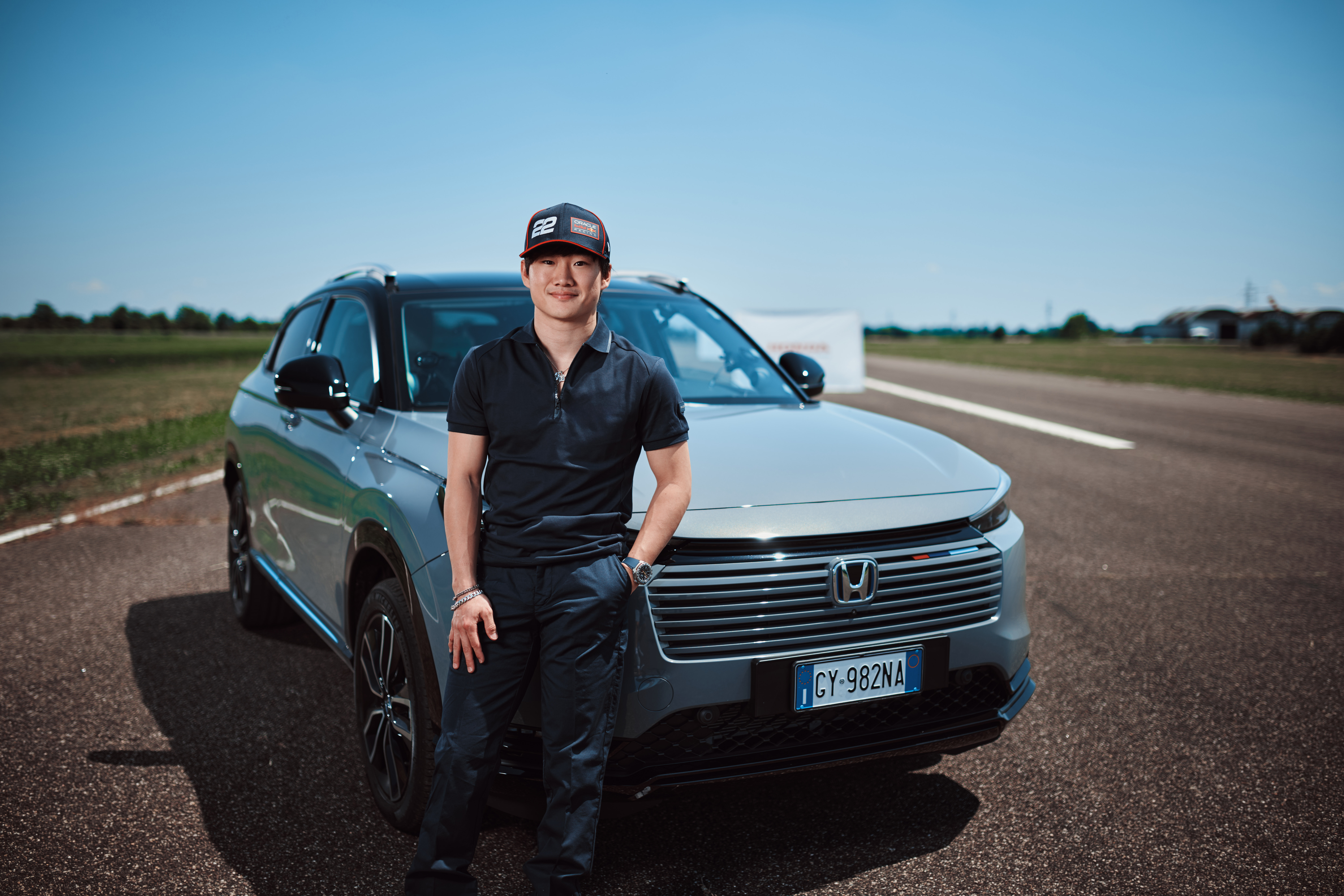 Yuki stoi obok kraty wlotu powietrza w Hondzie HR-V