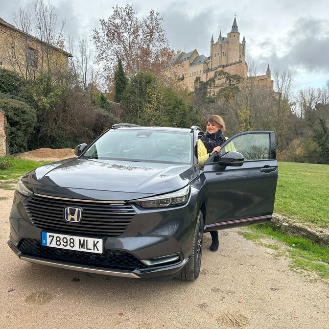 Influencer wsiadający do Hondy HR-V w zamkowej scenerii. 