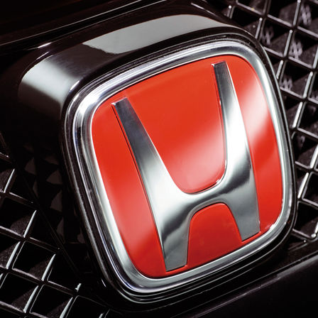 Zbliżenie na czerwonego logo „H” firmy Honda.