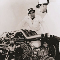 Soichiro Honda pracujący przy samochodzie wyścigowym.