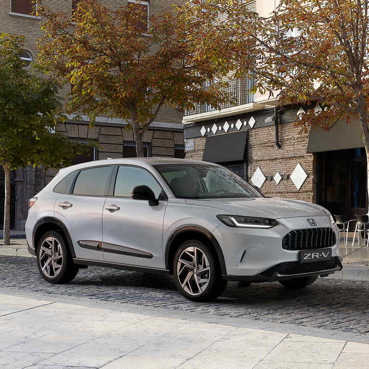 Widok z boku na Hondę ZR-V z pakietem Premium Black w miejskiej scenerii.