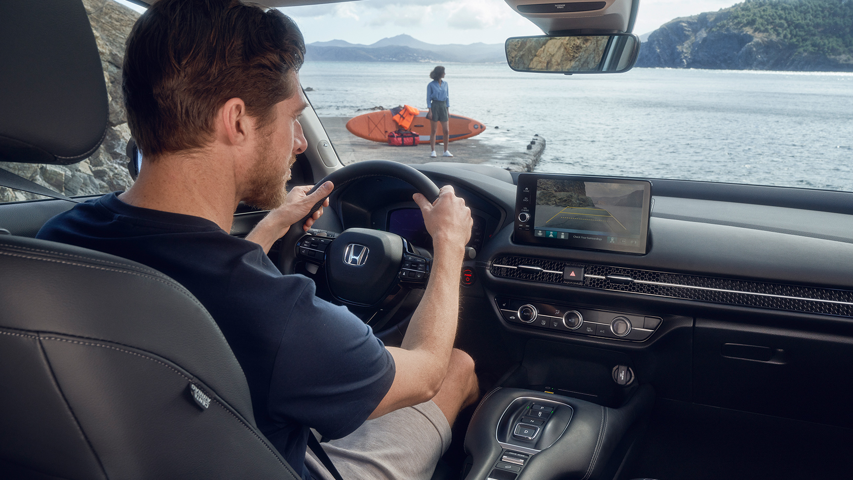 Mężczyzna jadący Hondą ZR-V z widocznymi funkcjami wspomagającymi parkowanie