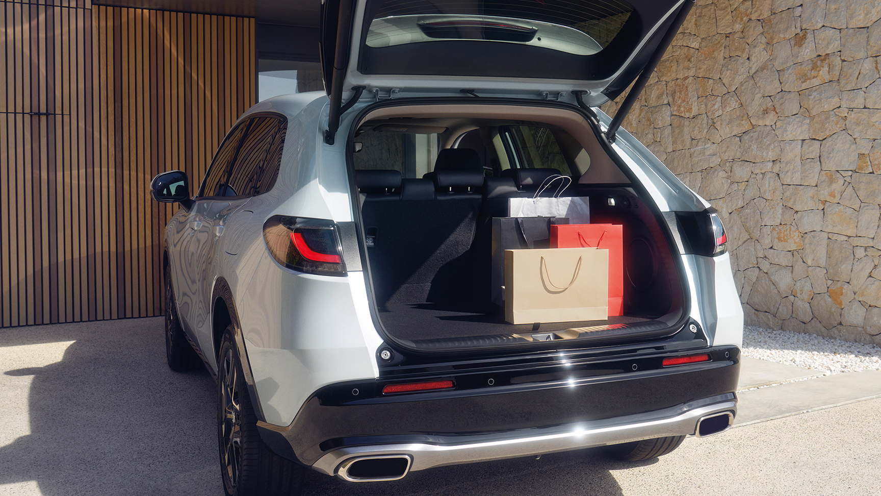 Biała Honda ZR-V z otwartym bagażnikiem na podjeździe