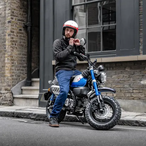 Honda Monkey 125 z kierowcą zaparkowana na poboczu drogi