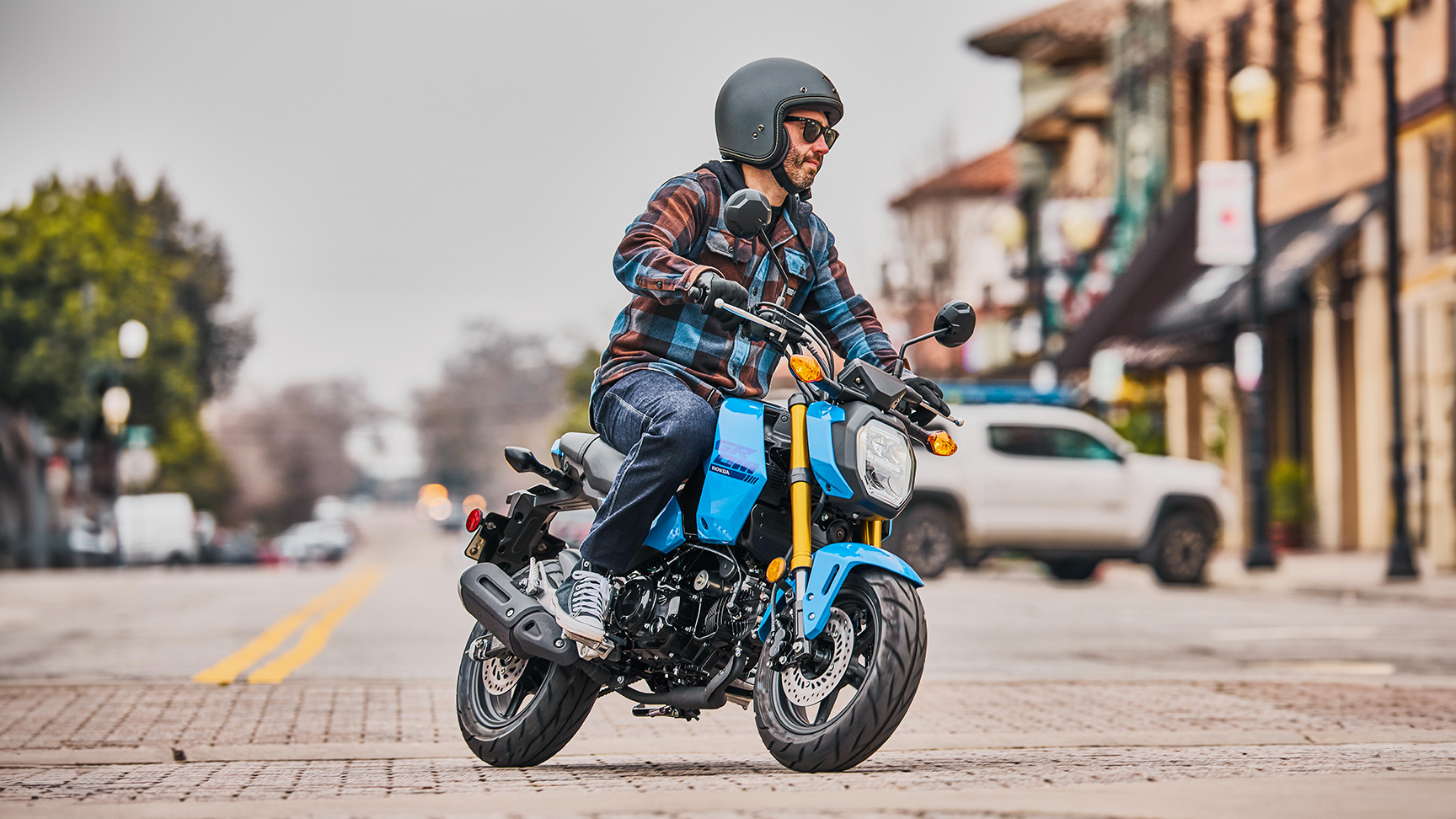 MSX125 Grom w kolorze niebieskim, na drodze, z kierowcą, w zakręcie 