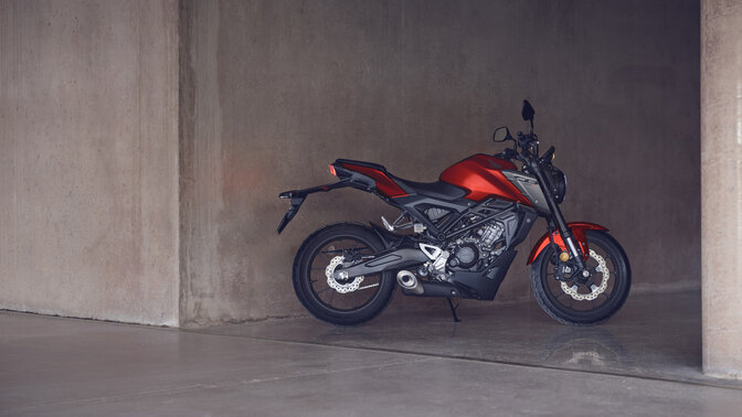 Honda Monkey oparta na bocznej stopce, na drodze, z kierowcą