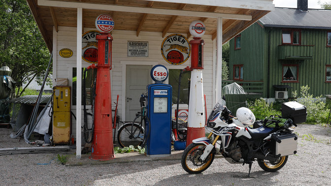 Motocykl zaparkowany na stacji benzynowej z dala od utartego szlaku.