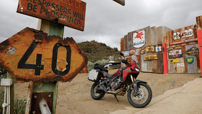 Honda CRF1000L Africa Twin zaparkowana przed przydrożną stacją benzynową.