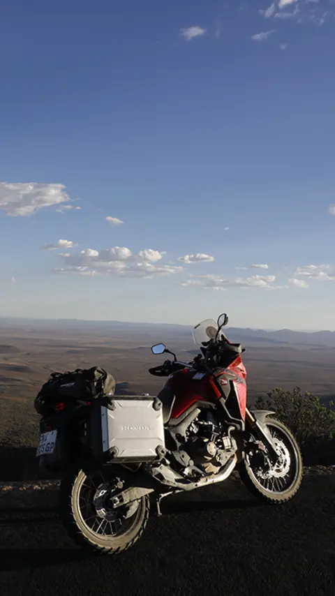 Honda CRF1000L Africa Twin zaparkowana na poboczu drogi z widokiem na pustynię Karoo.