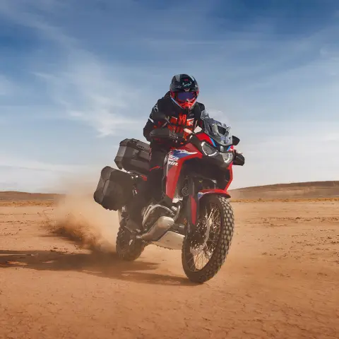 Motocyklista na Hondzie CRF1100 Africa Twin Adventure Sport w pustynnej scenerii.