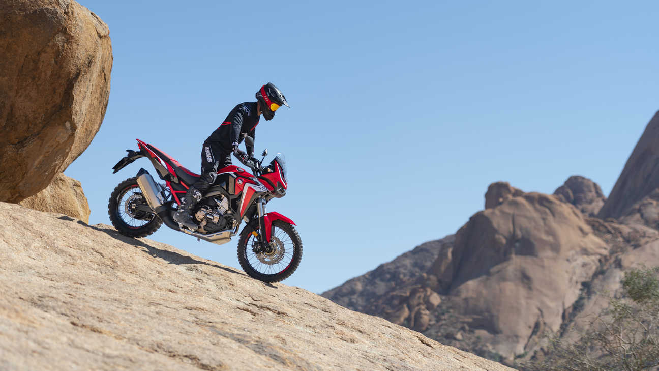 Honda Africa Twin - zdjęcie przedstawiające motocykl zjeżdżający ze skały z prawego profilu
