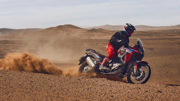 Model jadący po pustyni na motocyklu CRF1100L Africa Twin.