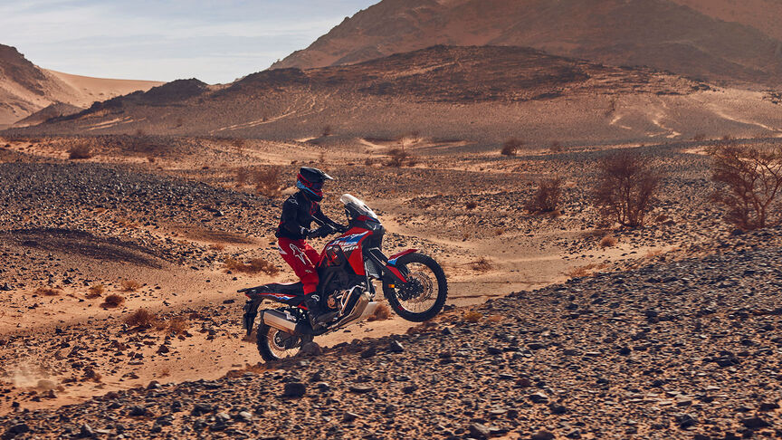 Model jadący po pustyni na motocyklu CRF1100L Africa Twin.