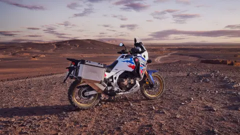 Motocyklista na Hondzie CRF1100 Africa Twin Adventure Sports w pustynnej scenerii.