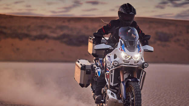 Motocyklista na Hondzie CRF1100 Africa Twin Adventure Sports w pustynnej scenerii.