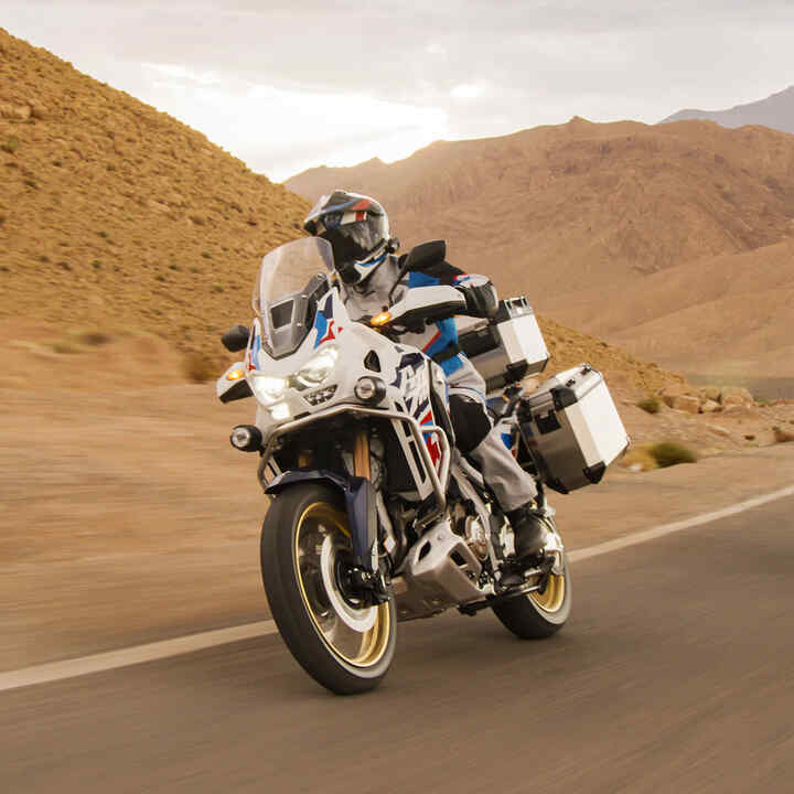 Motocyklista na Hondzie CRF1100 Africa Twin Adventure Sports w pustynnej scenerii.