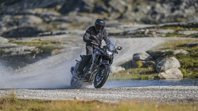 Honda CB500X jadąca przez wodę.