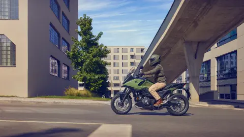 Boczne ujęcie modela jadącego na motocyklu NC750X w mieście.