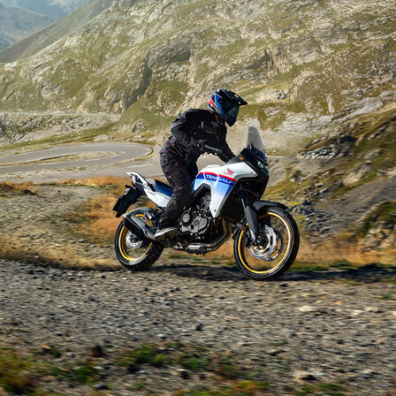 XL750 Transalp na szutrowym torze na tle gór.